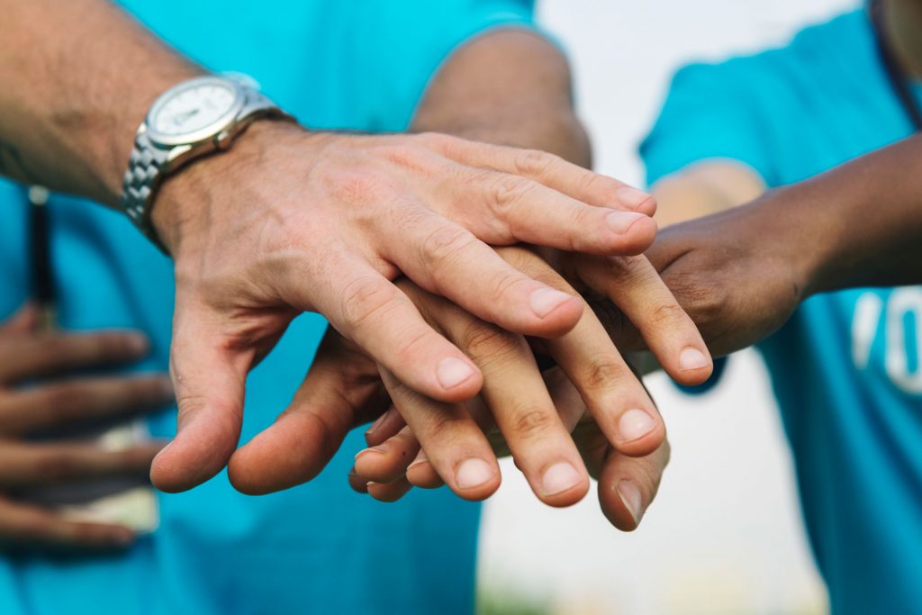 team-volunteers-stacking-hands-small
